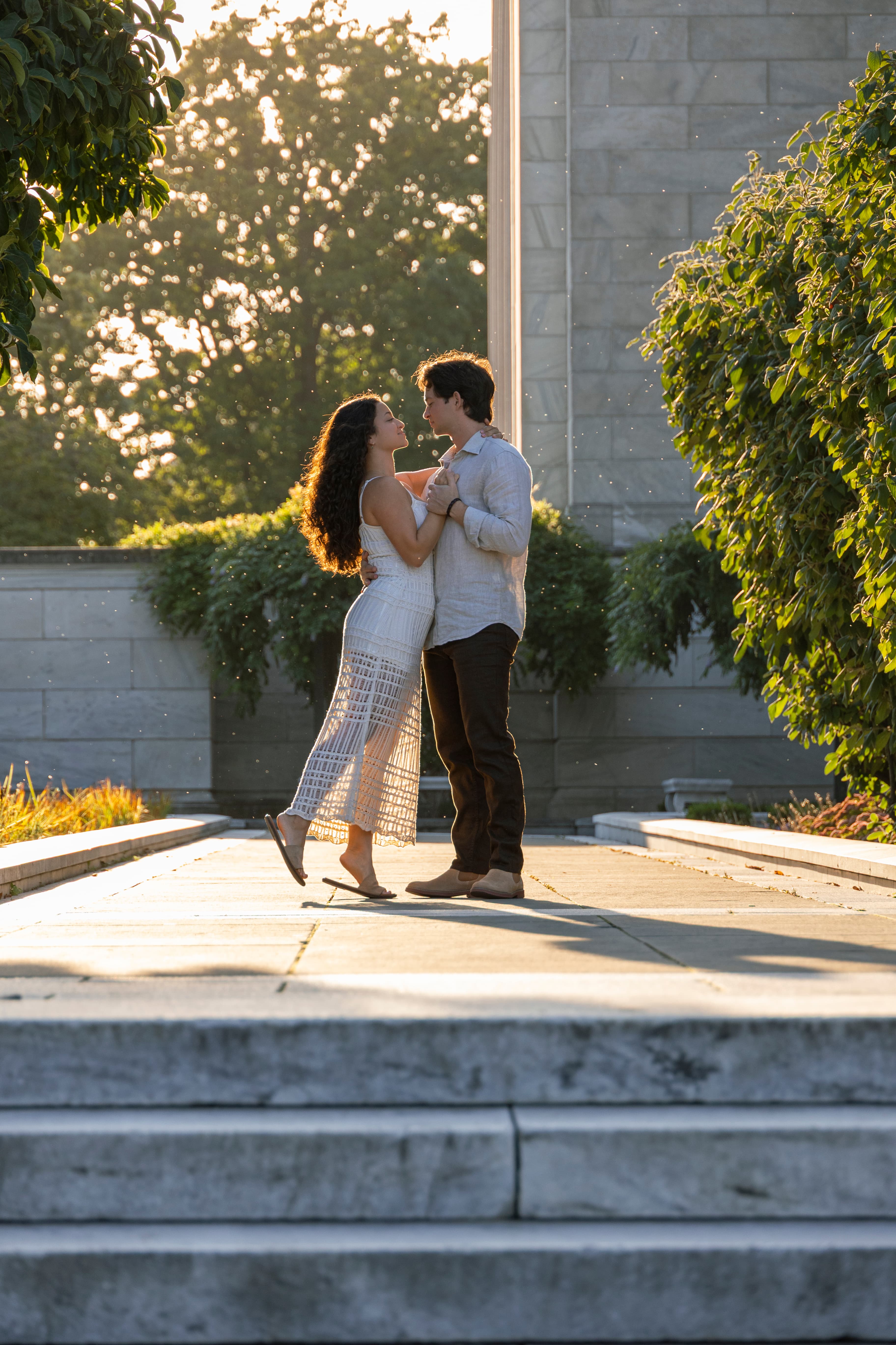 Couple dancing in golden light by stone columns