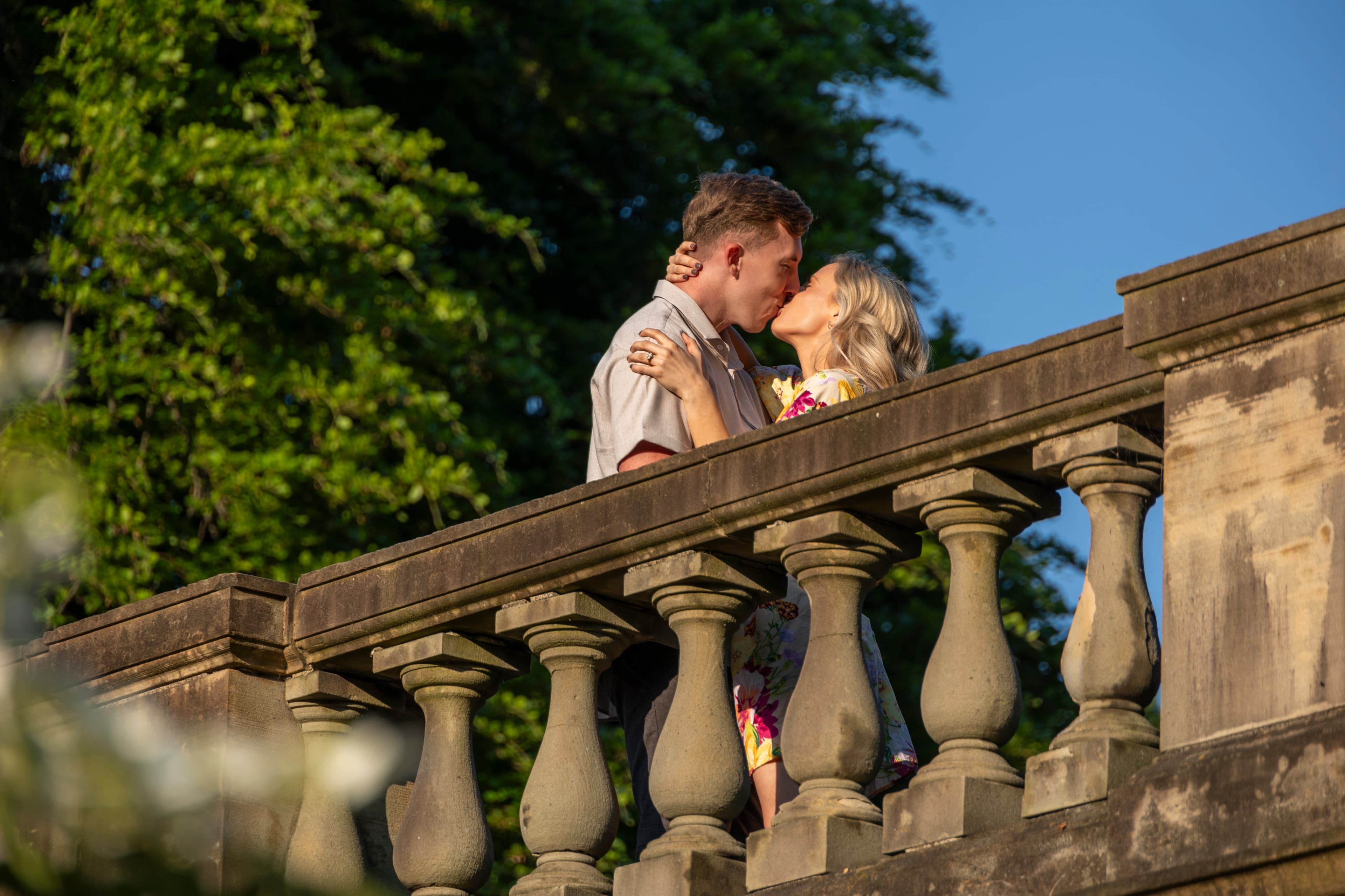 Couple kissing on a stone terrace balustrade