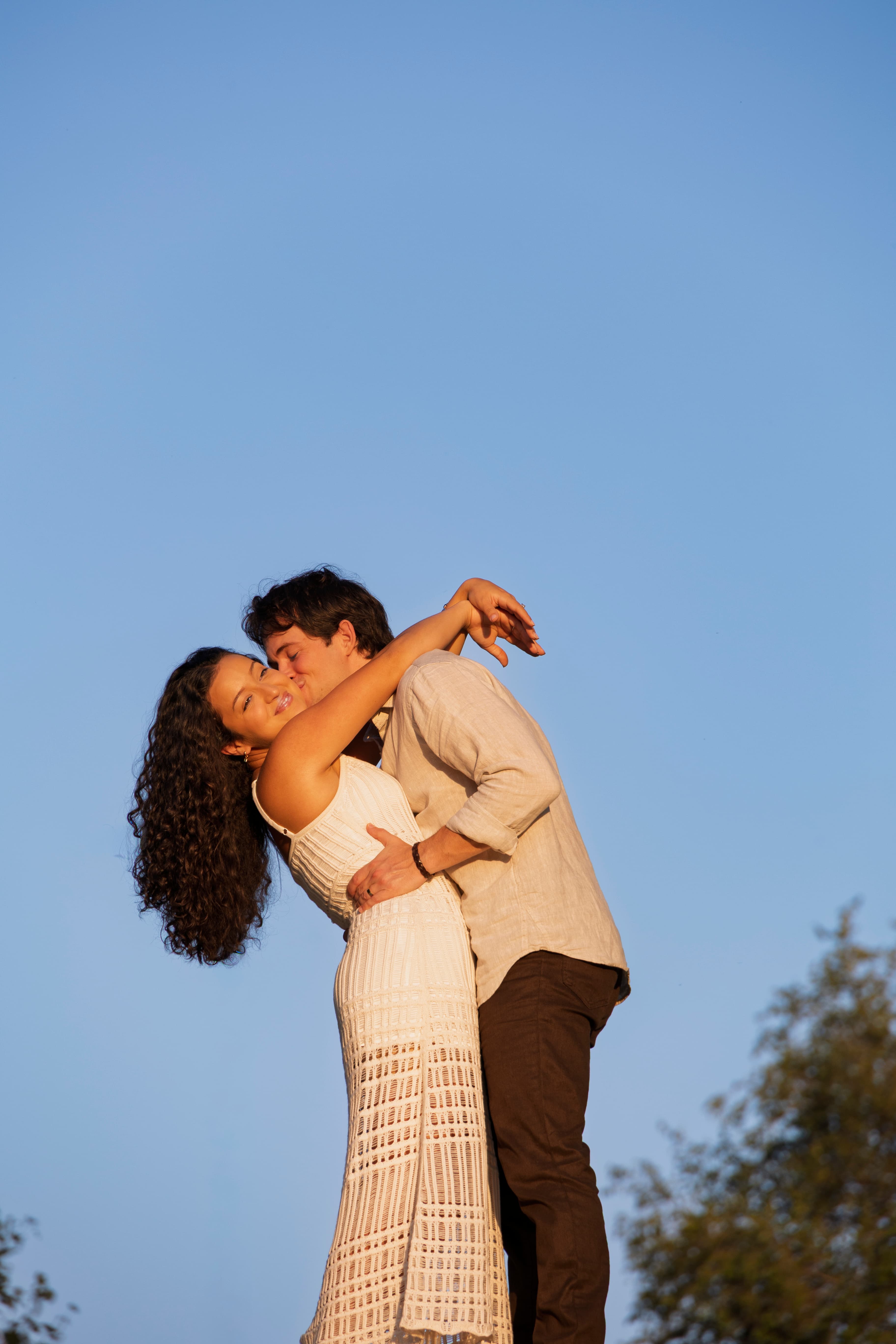 Couple dancing and spinning under a blue summer sky