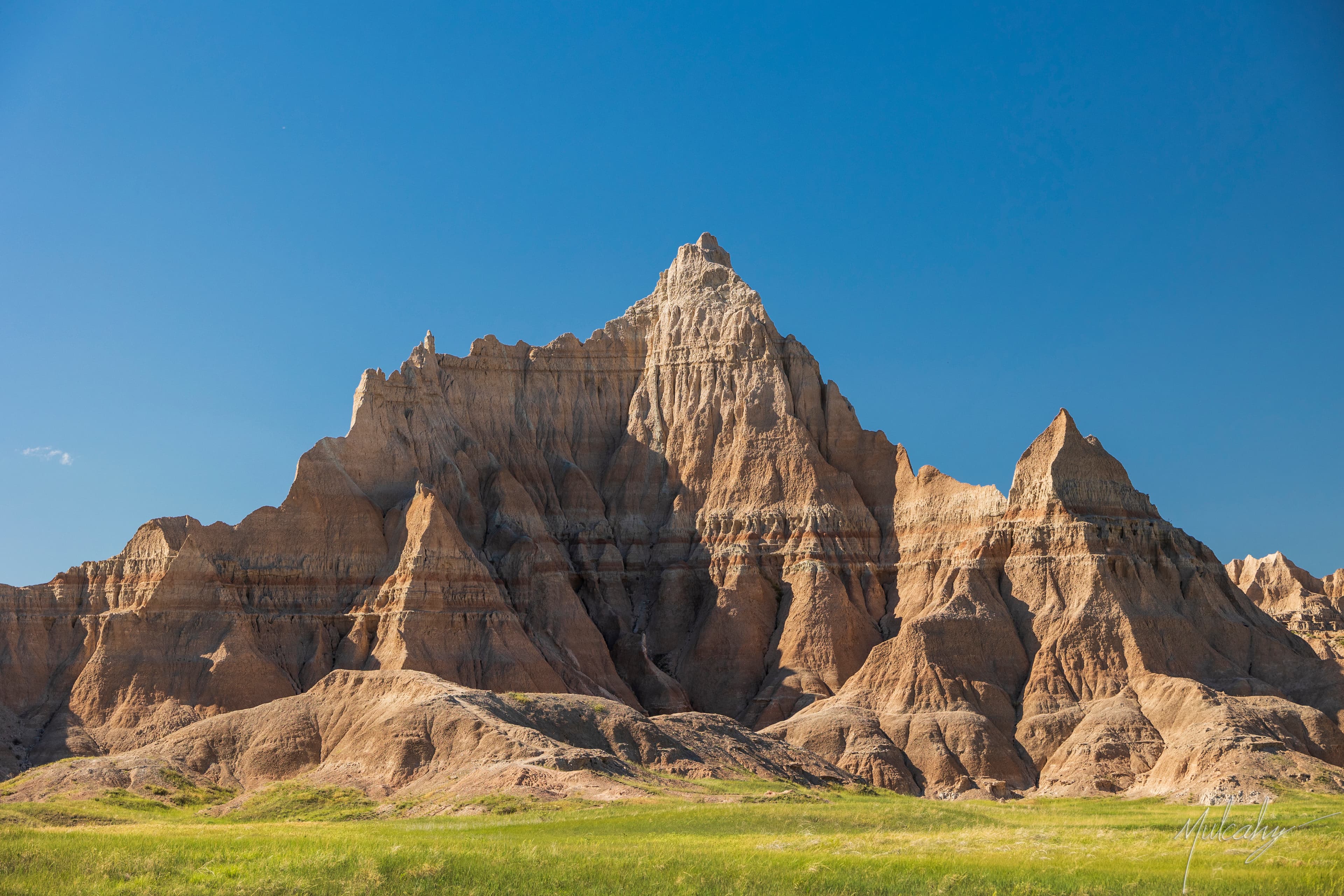 Dramatic sandstone buttes rising from the Badlands under blue sky