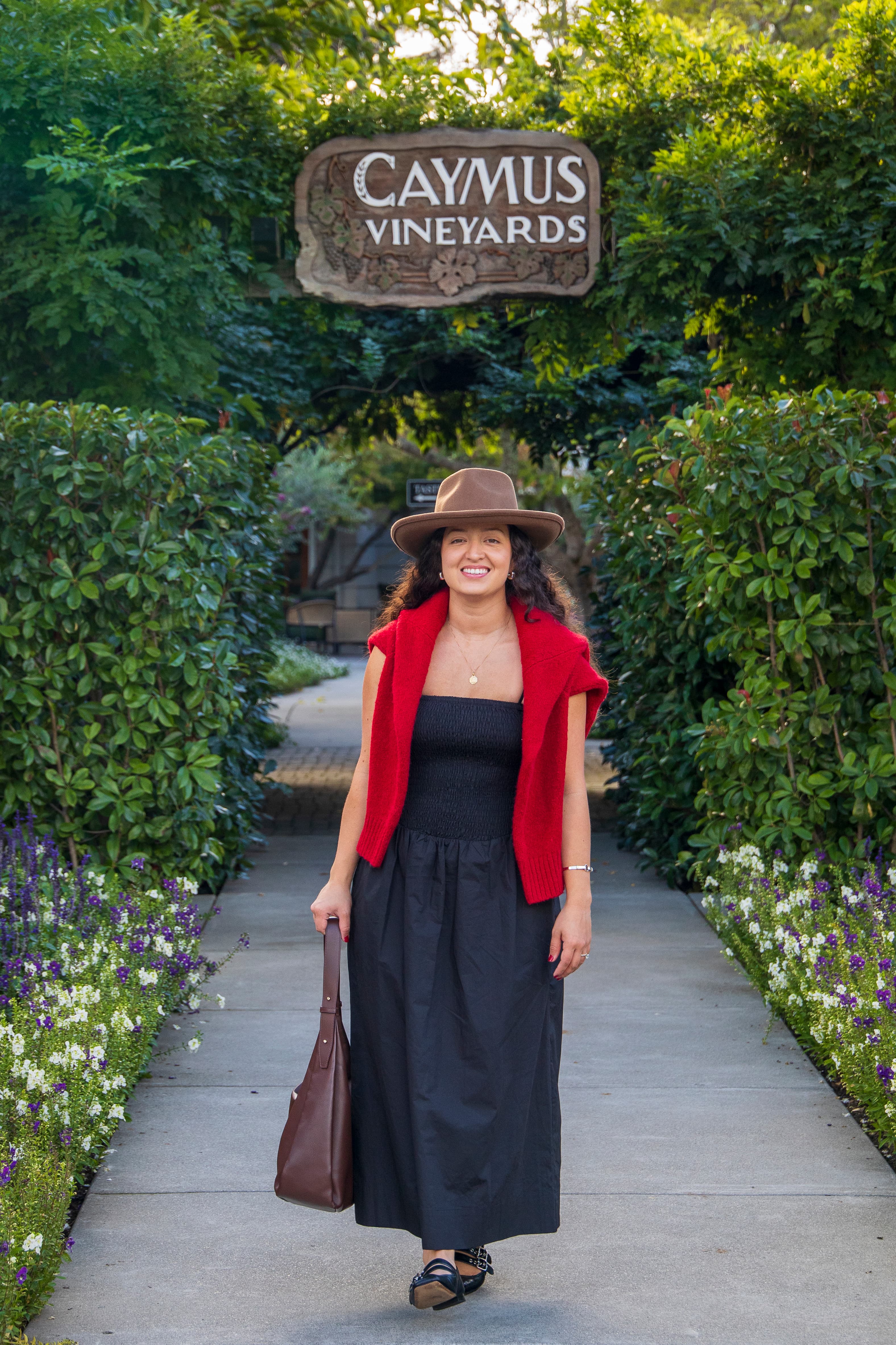 Woman walking through the entrance of Caymus Vineyards, Napa